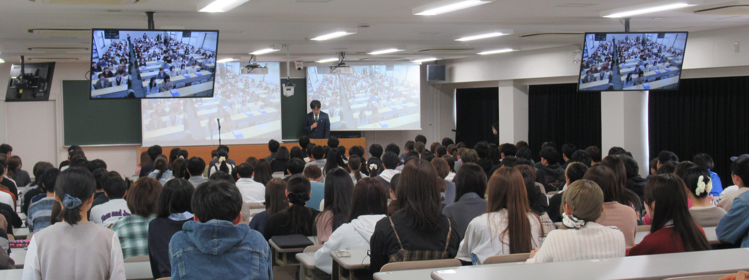開課程式の全景。スクリーン越しに両大学が繋がっている様子